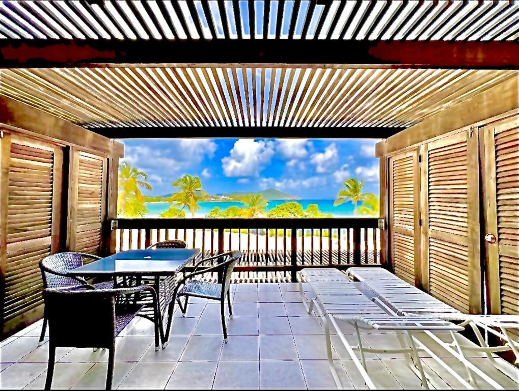a patio with a table and chairs on a balcony at Sapphire Beachfront Condo - View of Paradise - Free Wi - Fi C-7 in East End