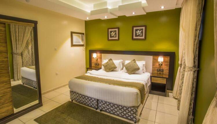 ein Schlafzimmer mit einem großen Bett und einer grünen Wand in der Unterkunft للايجار المفروش يومي شهري سنوي in Assuan