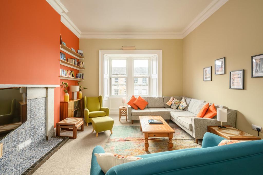 a living room with a couch and a fireplace at 5-BR 3-BTH Newington Apartment - Modern & Spacious in Edinburgh