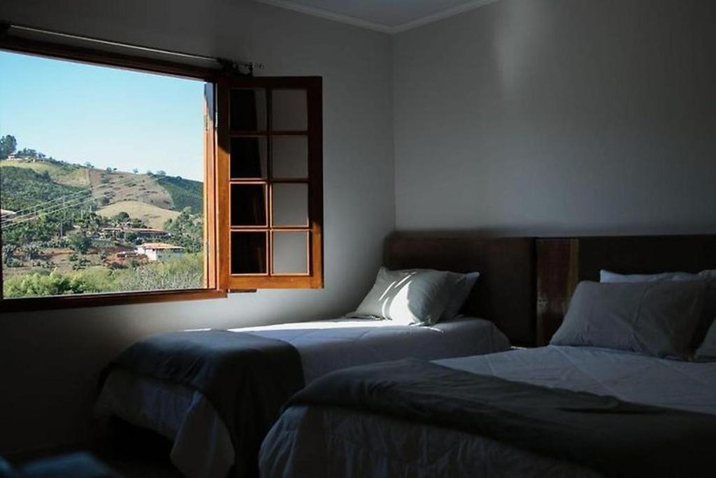two beds in a room with a window at Hotel Manoah in Socorro