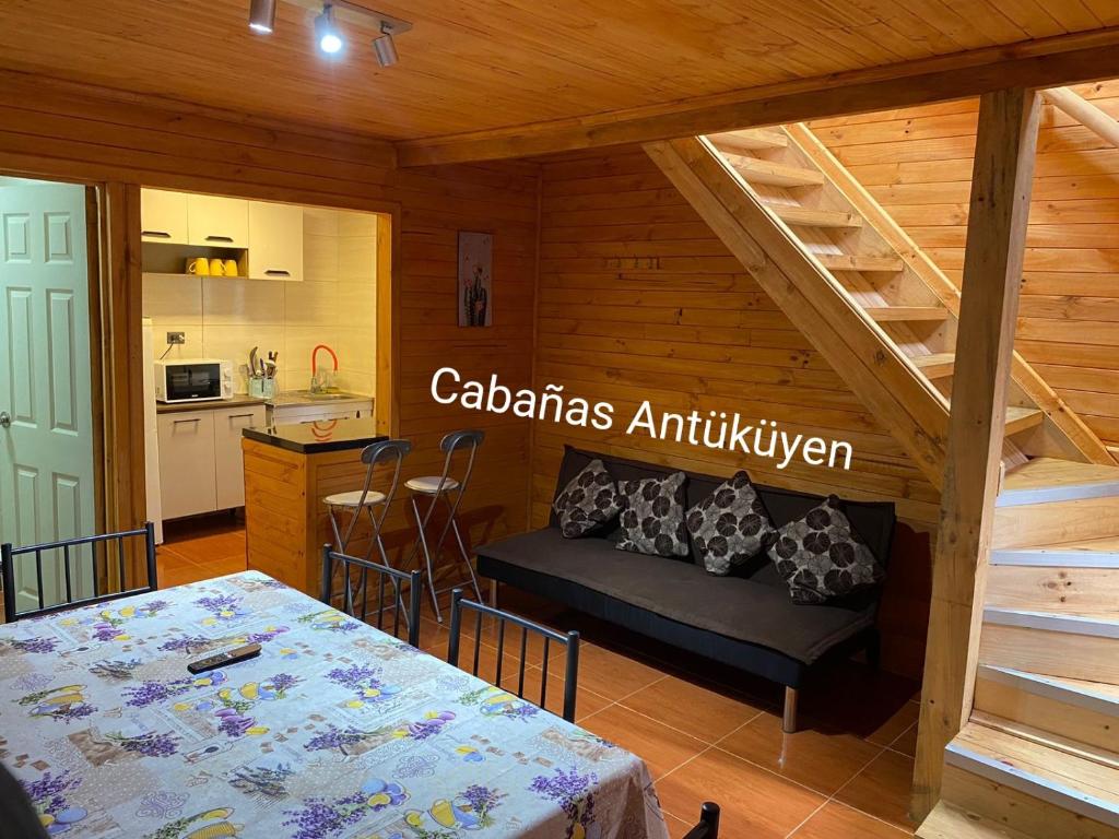 sala de estar con mesa y cocina en CABAÑAS ANTU KUYEN en Pichilemu