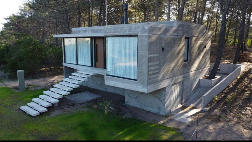 a small house with glass windows and stairs at Monte Hermoso in Monte Hermoso