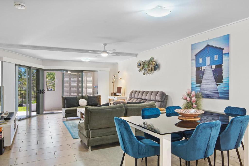 a living room with a table and blue chairs at Dream Time Direct Beach Access in Agnes Water