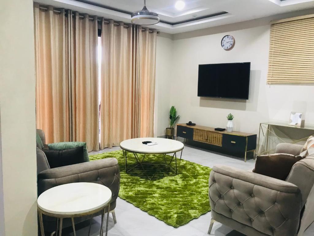 sala de estar con sofá y TV en Ultramodern 2 bedroom space Available en Accra