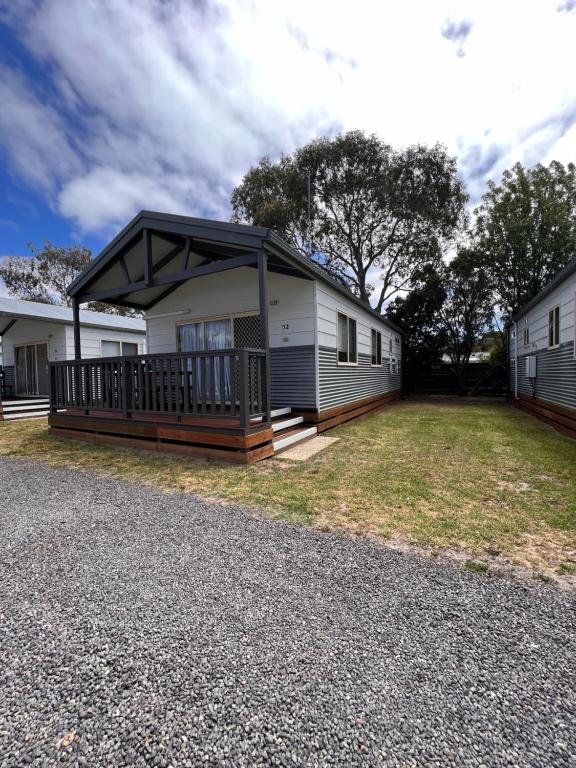 a mobile home with a porch and a roof at Ocean Grove Holiday Park in Ocean Grove