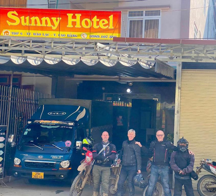 un grupo de hombres parados frente a un hotel soleado en Bảo Lạc - Sunny Homestay, en Bảo Lạc