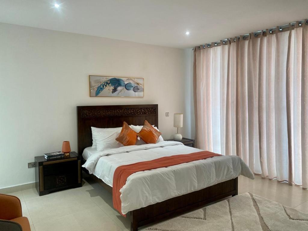 a bedroom with a large bed and a large window at Elegant 3 Bedroom Space Available in Accra