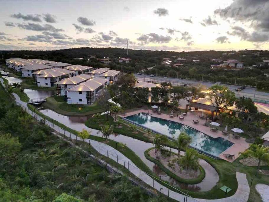 een luchtzicht op een resort met een zwembad bij Praia do Forte: apto studio com mezanino in Mata de Sao Joao