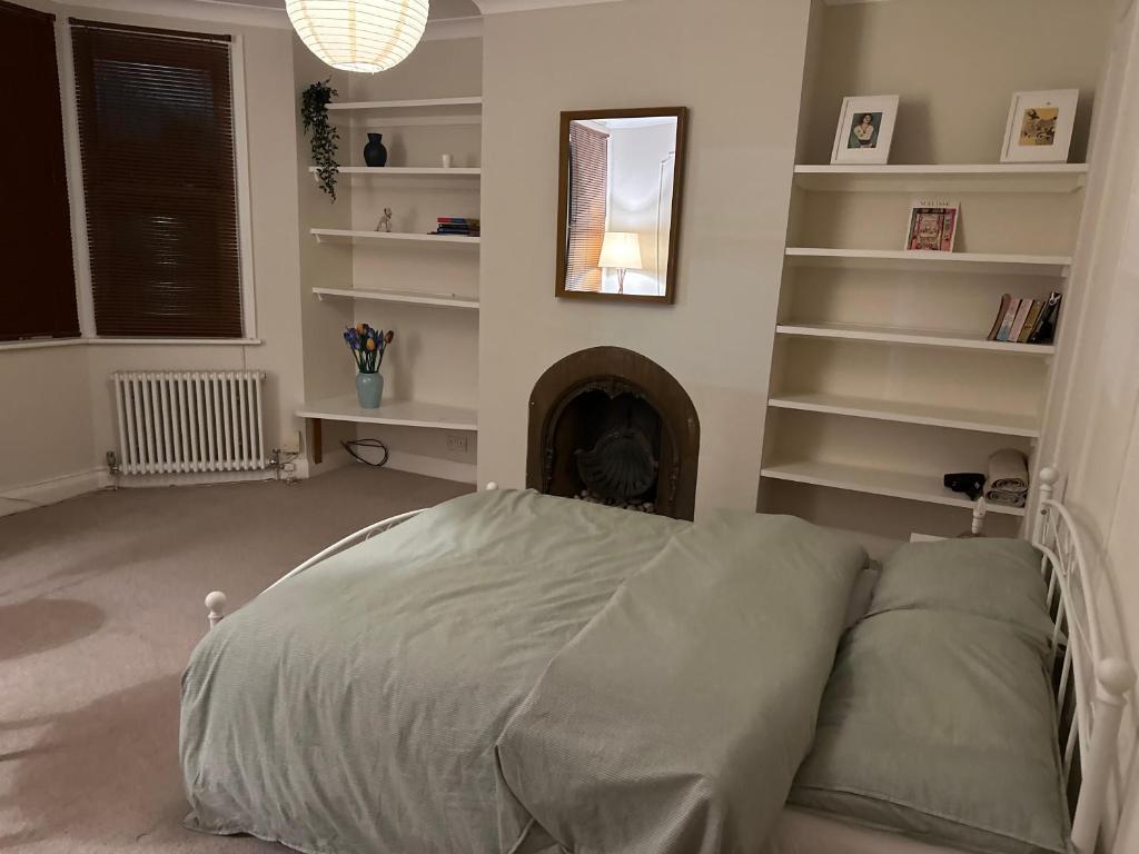 - une chambre avec un lit et une cheminée dans l'établissement Spacious room near underground, à Londres