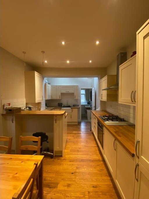 cocina con mesa y suelo de madera en Delightful Victorian House, en Mánchester