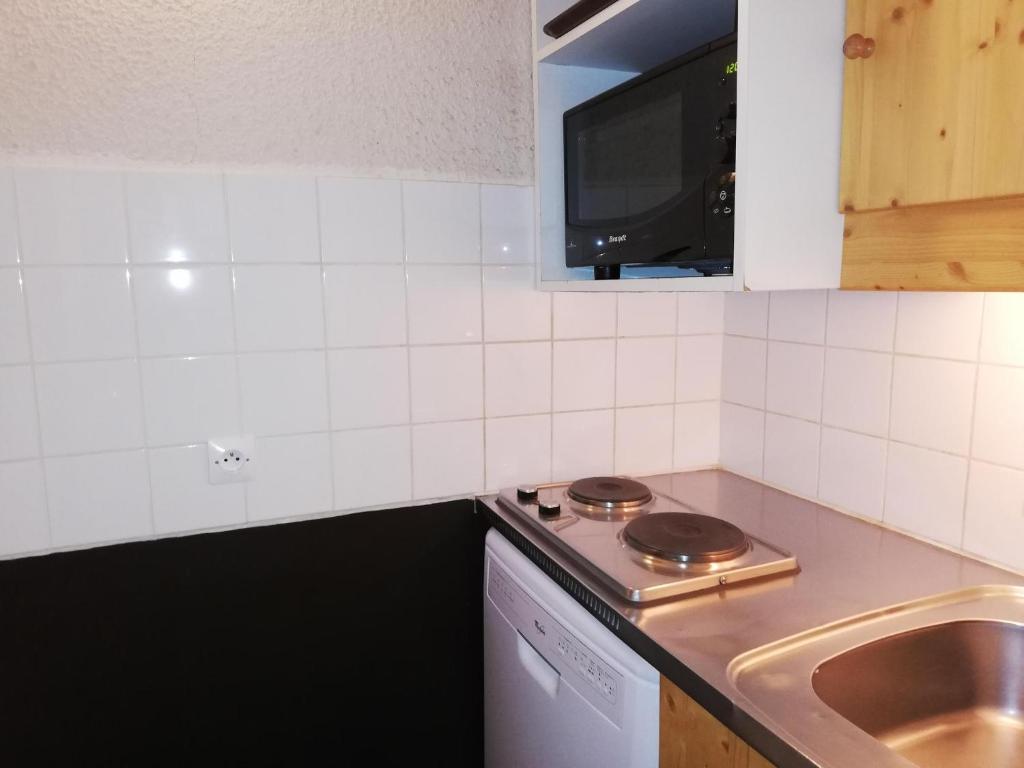 eine kleine Küche mit Herd und Spüle in der Unterkunft Appartement Valmorel, 1 pièce, 4 personnes - FR-1-356-284 in Valmorel