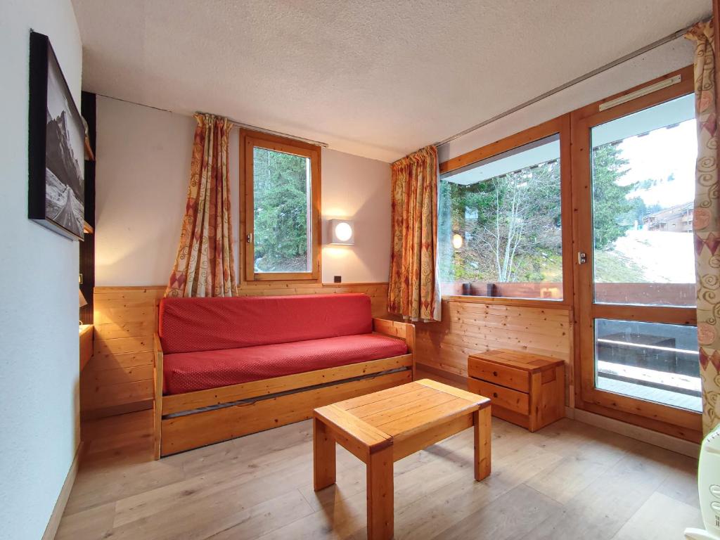 a living room with a red couch and a window at Appartement Valmorel, 1 pièce, 4 personnes - FR-1-356-257 in Valmorel