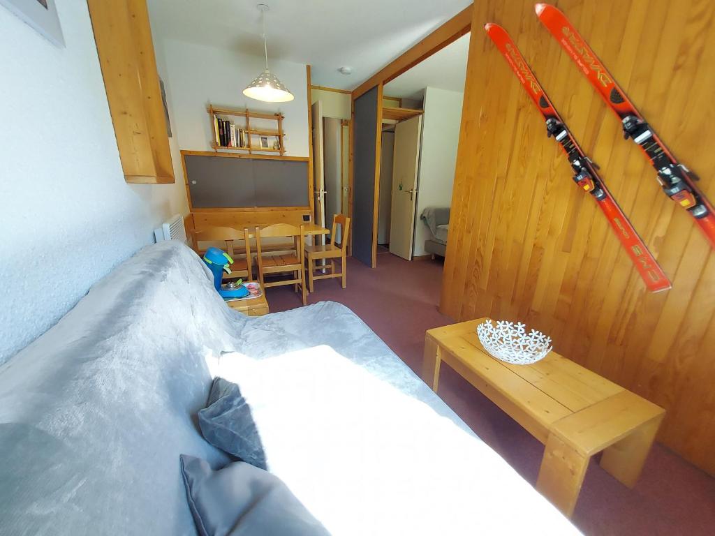 ein Schlafzimmer mit einem Bett und einem Tisch mit Skiern an der Wand in der Unterkunft Appartement Valmorel, 1 pièce, 4 personnes - FR-1-356-258 in Valmorel