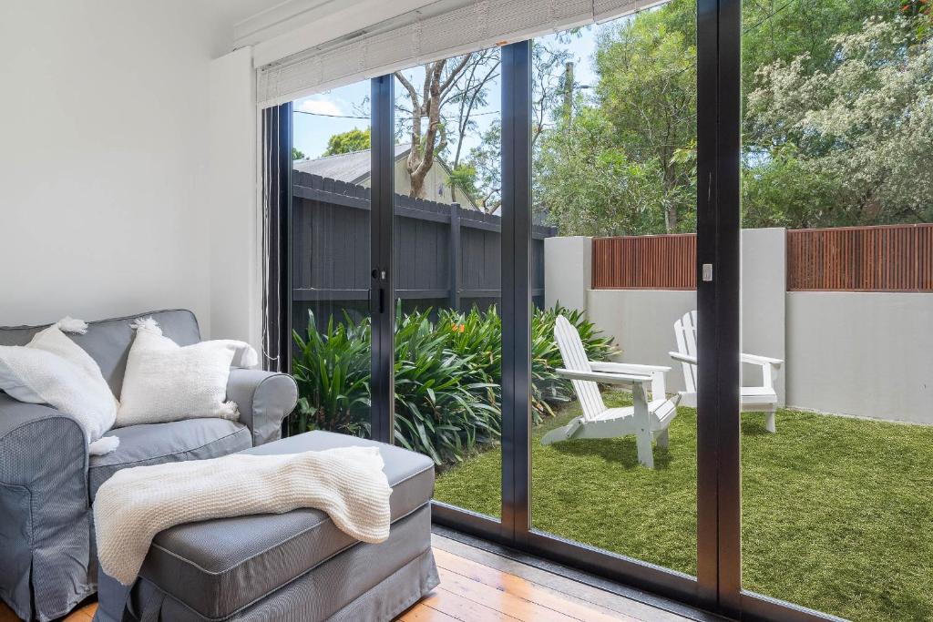 a living room with a couch and glass doors at Charming 3 Bedroom Artist House in Mosman in Sydney