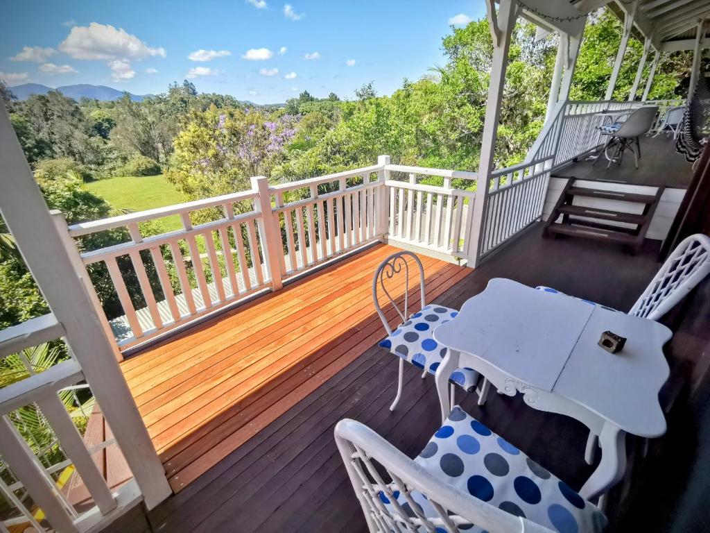 a deck with a table and chairs on a porch at Bellingen Belfry Guesthouse in Bellingen