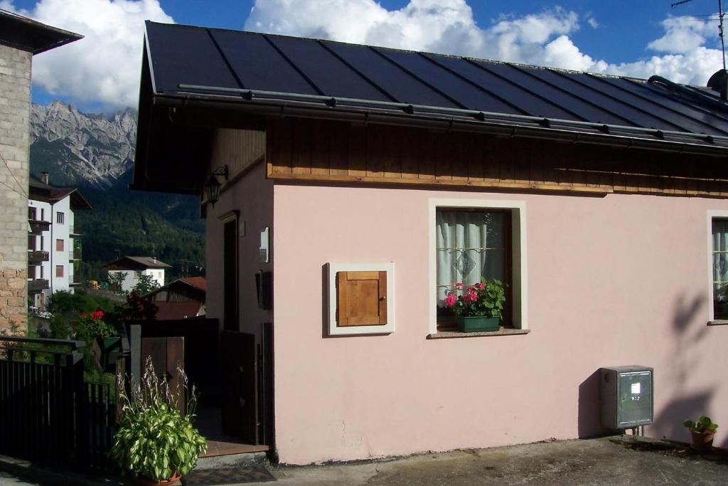 Una casa con una ventana con flores. en Fabbricato Indipendente Centro, en Lozzo Cadore