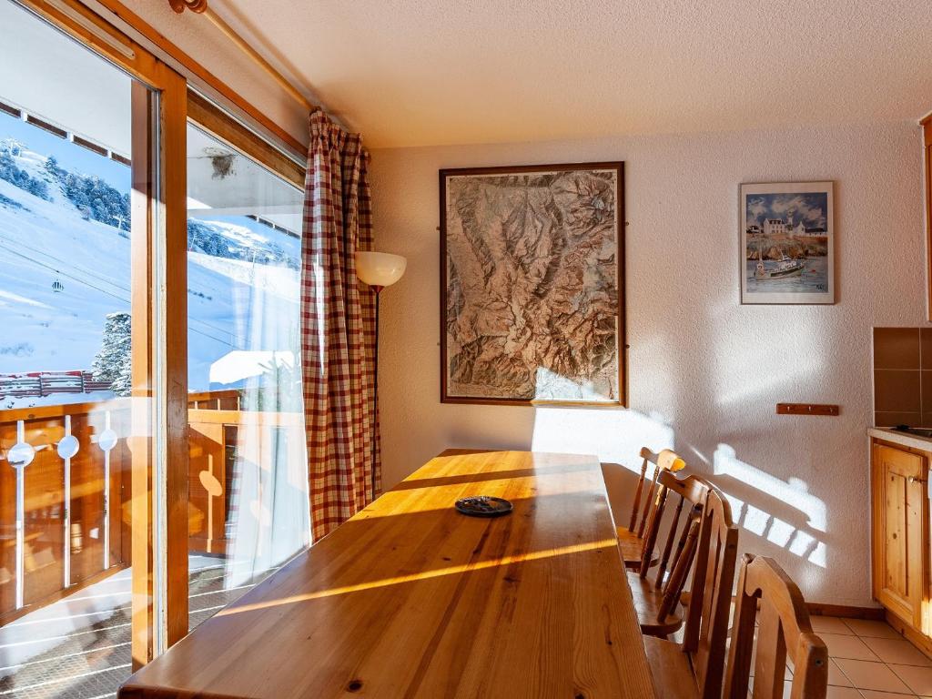 a dining room with a wooden table and a large window at Appartement Méribel, 3 pièces, 6 personnes - FR-1-355-48 in Méribel