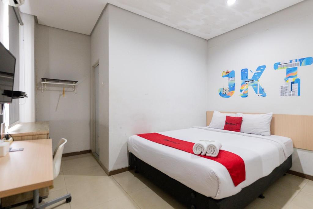 um quarto com uma cama com duas toalhas em RedDoorz Plus Syariah near Mall Pondok Indah em Jakarta