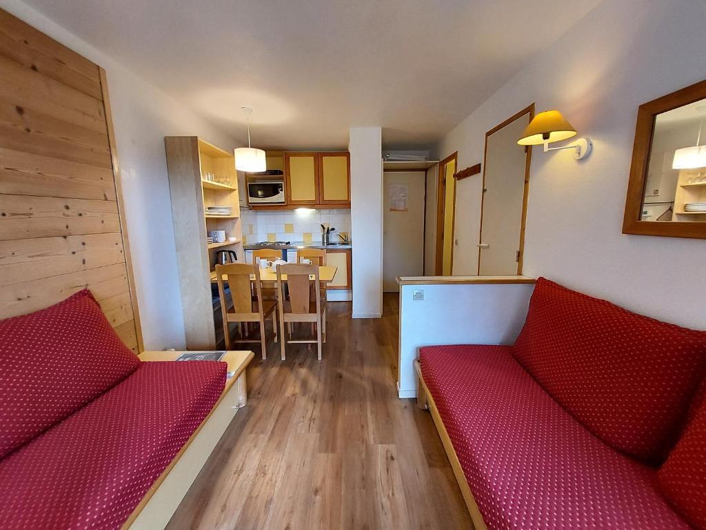 ラ・プラーニュにあるAppartement La Plagne, 2 pièces, 6 personnes - FR-1-353-64のリビングルーム(赤いソファ2台付)、キッチンが備わります。