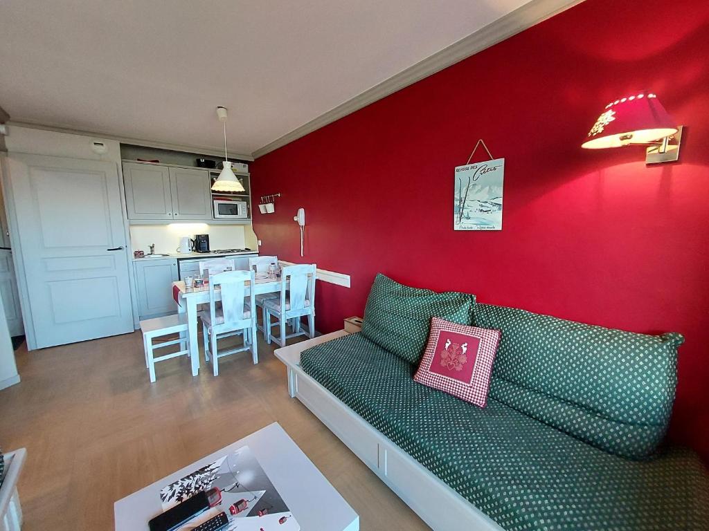ラ・プラーニュにあるAppartement La Plagne, 2 pièces, 5 personnes - FR-1-353-65の赤い壁のリビングルーム(緑のソファ付)