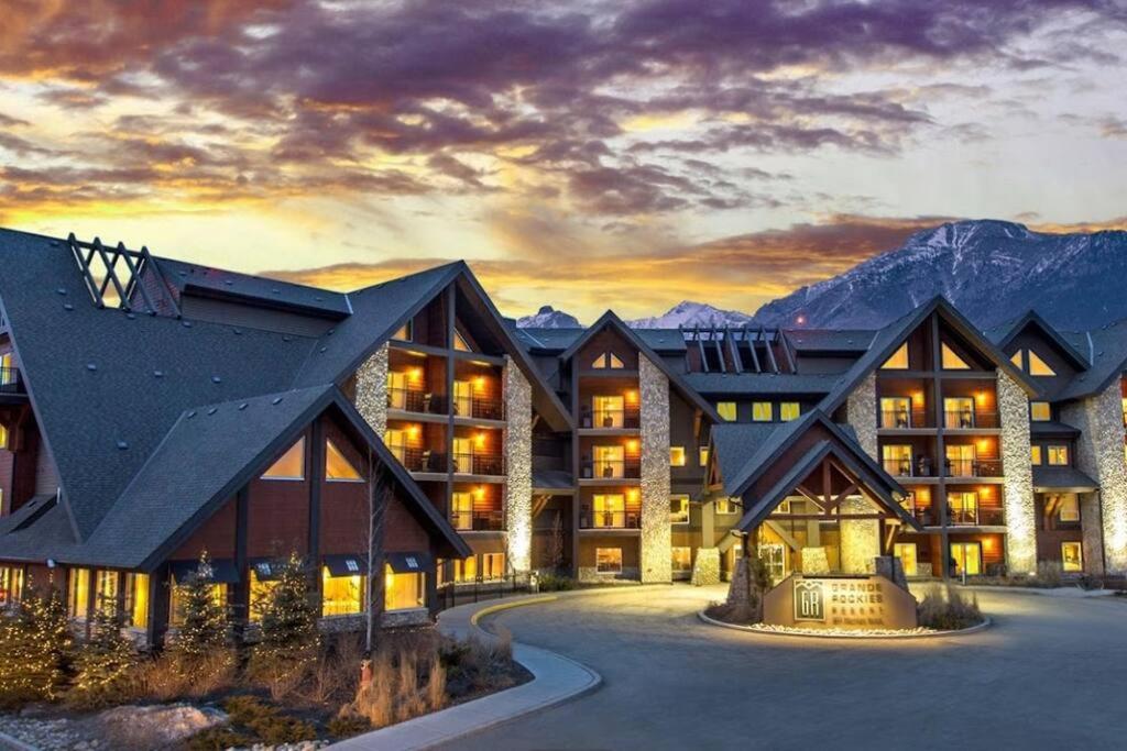 a resort in the mountains with the sun setting at Family Fun- MTN View Stay, Water slide, Pool, Hot Tub, Free Parking in Canmore