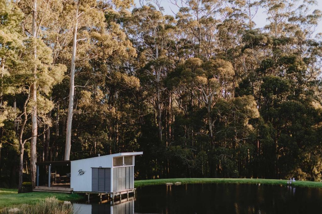 una casita en el agua frente a los árboles en 17pounds Country Estate & Aqua Wellness Retreat, en Bullarto