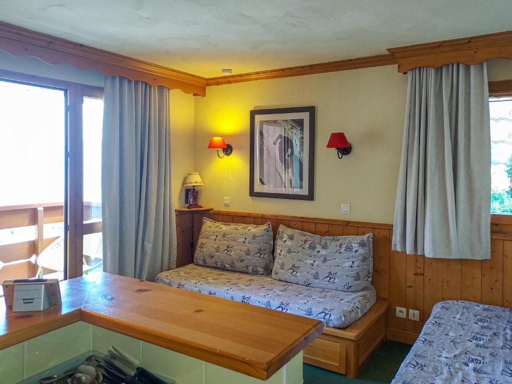 a bedroom with a bed and a table in a room at Appartement Valmorel, 2 pièces, 4 personnes - FR-1-356-424 in Valmorel