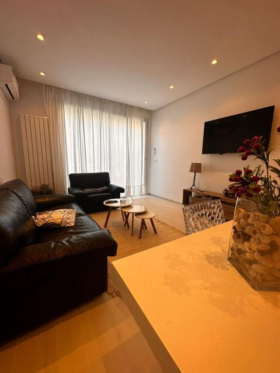 un soggiorno con divano in pelle e tavolo di App avec jardin dans un hôtel a Gammarth