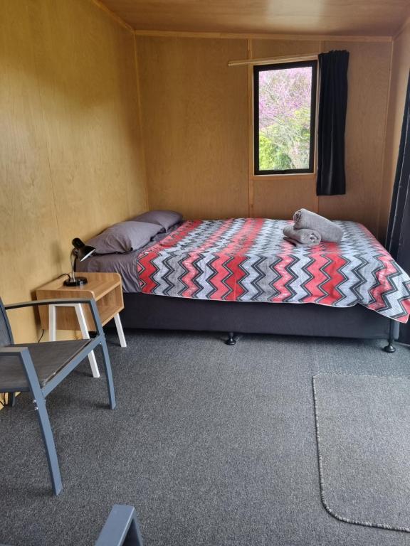 a bedroom with a bed and a table and a window at Murchison Motorhome Park in Murchison