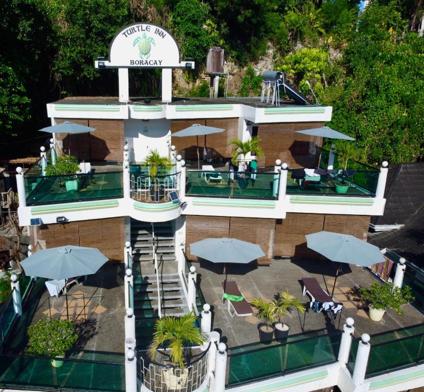 una vista aérea de un edificio con mesas y sombrillas en Turtle Inn Resort, en Boracay