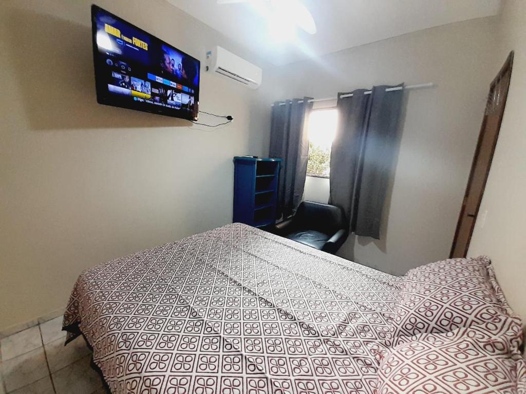 um quarto com uma cama e uma TV na parede em 2 quartos com ar - Apto em condomínio em Campo Grande