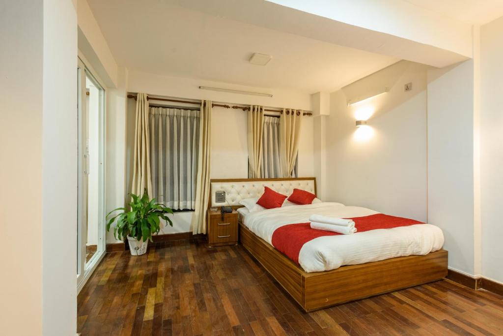Un dormitorio con una cama y una planta. en Sichu Chhen en Pātan