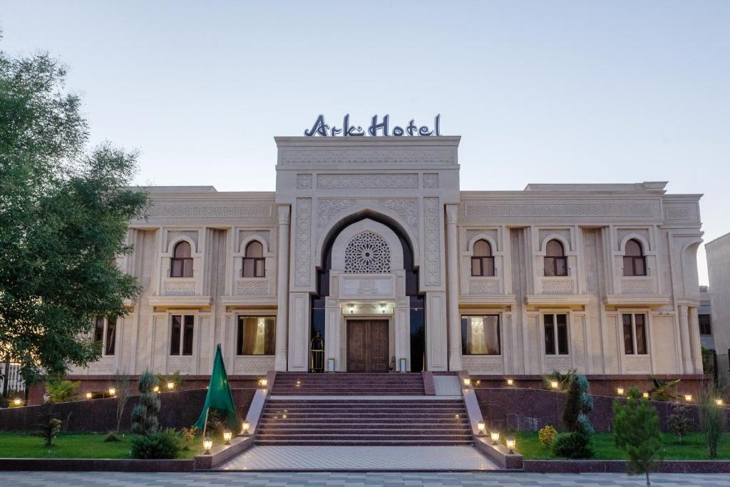 a large white building with stairs leading into it at Ark Hotel in Bukhara