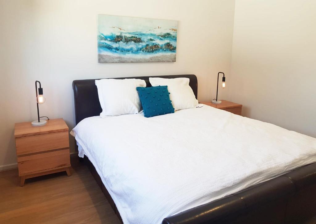 a bedroom with a large bed with two night stands at Normanville Getaway House in Normanville