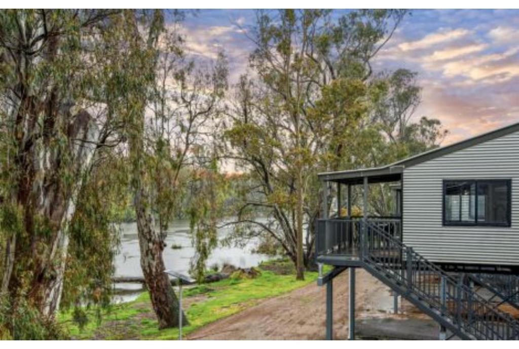 a house with a deck next to a body of water at Discovery Parks - Nagambie Lakes in Nagambie
