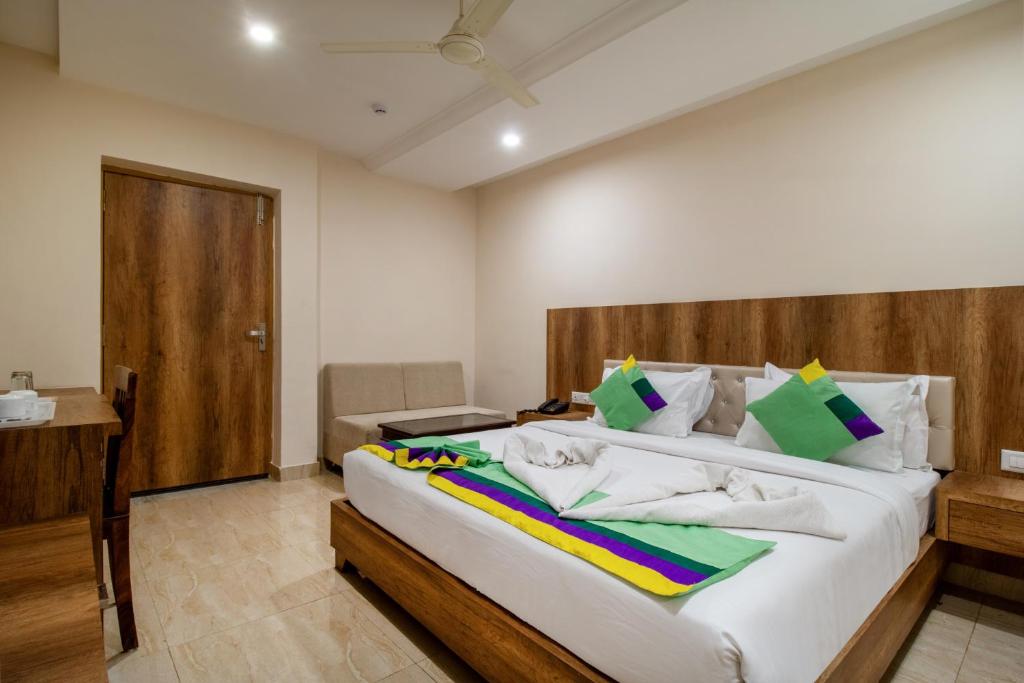 a bedroom with a large bed with a wooden headboard at Treebo Trend Sonal Palace 1 Km From Jodhpur Airport in Jodhpur