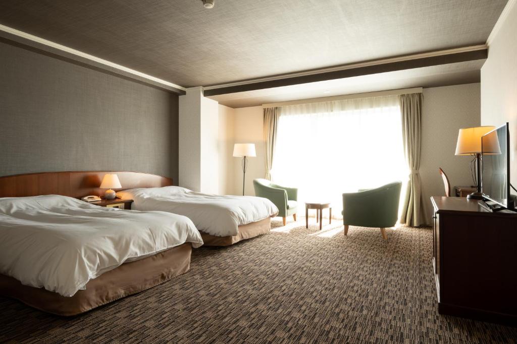 Postel nebo postele na pokoji v ubytování Hashidate Bay Hotel