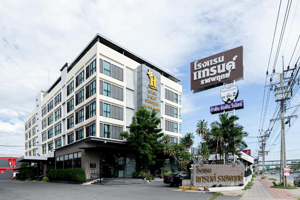 a large white building with a sign in front of it at Grand Ratchapruek Hotel in Ban Bang Phlap