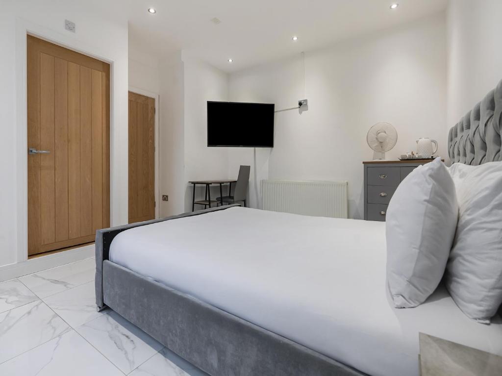 a bedroom with a large white bed and a television at OYO Bellevue Apartments Middlesborough in Middlesbrough