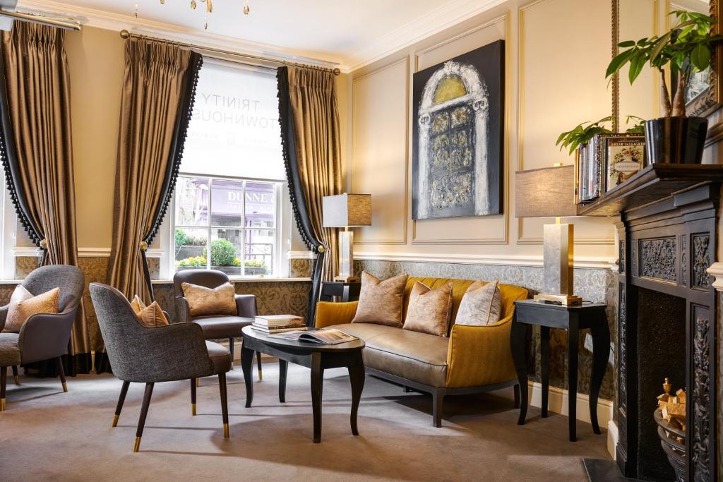 een woonkamer met een bank en stoelen en een open haard bij Trinity Townhouse Hotel in Dublin