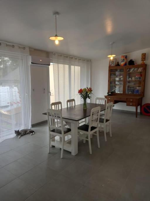 - une salle à manger avec une table, des chaises et un vase de fleurs dans l'établissement Maison 3 chambres circuit des 24h Le Mans, au Mans