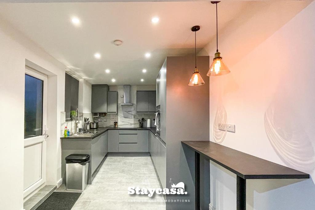 eine Küche mit grauen Schränken und einer Arbeitsplatte in der Unterkunft Live In Style House In Desirable Location in Manchester