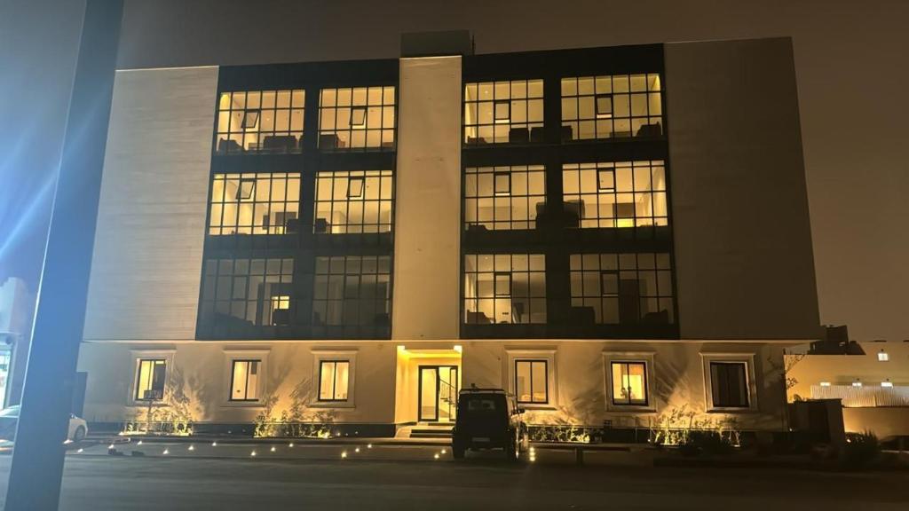 um grande edifício com janelas iluminadas à noite em Mayyon Airport 102 em Riyadh