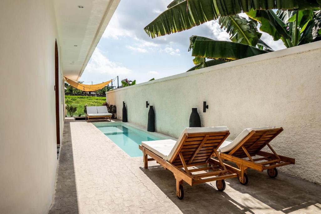 deux chaises assises à côté d'une piscine dans l'établissement Spacious Design Villa 3bd, à Canggu