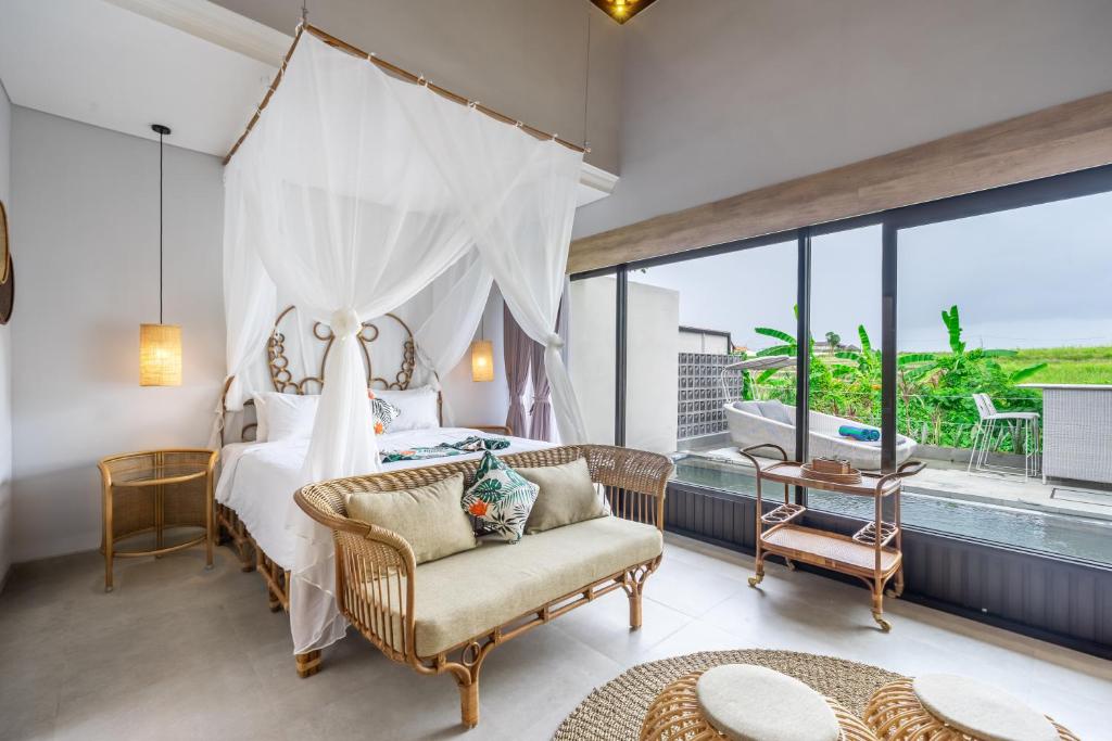 a bedroom with a bed and a large window at Kulta Villa Bali in Munggu