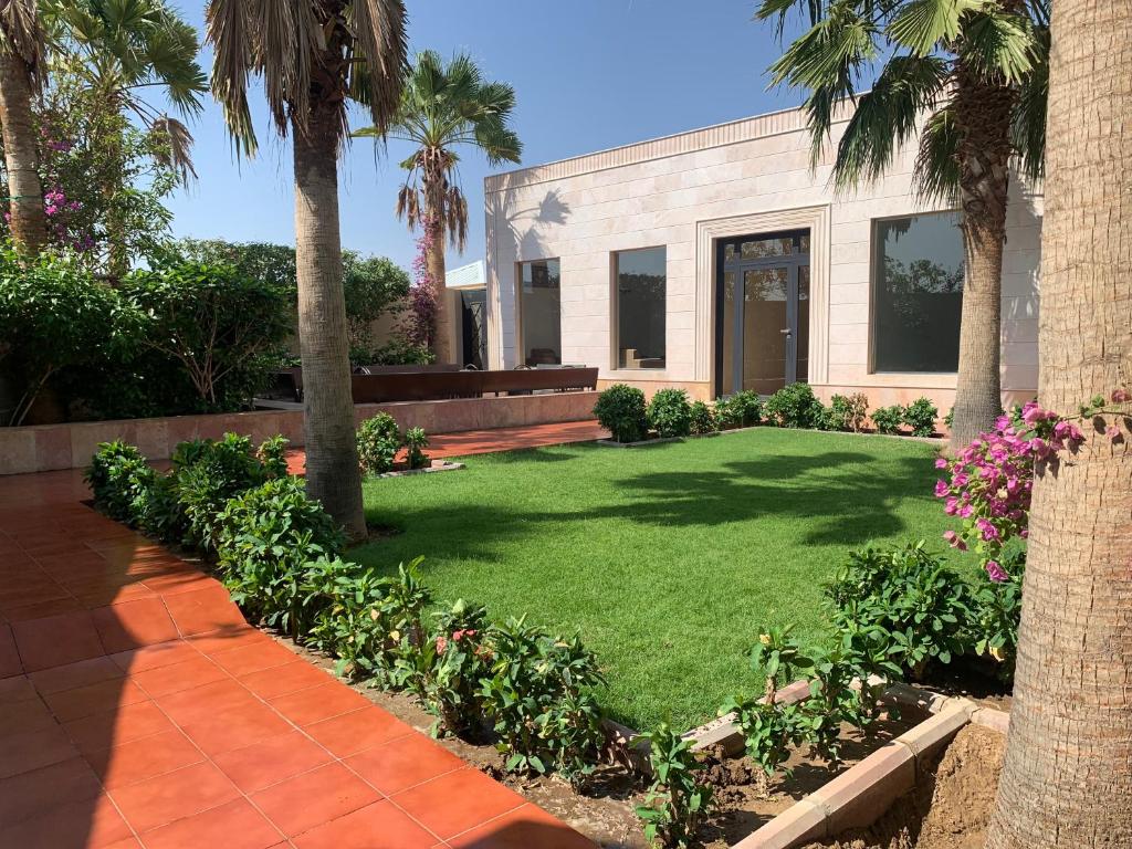 un patio con palmeras y un edificio en فيلا المنزل en Makkah