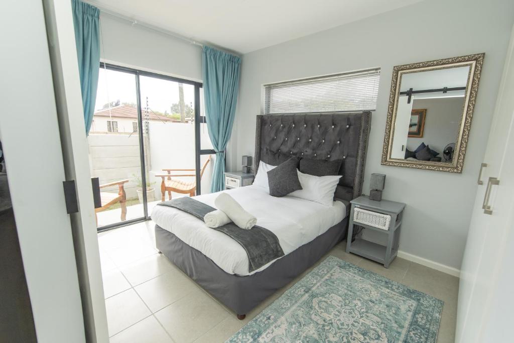 a bedroom with a large bed and a mirror at Cozy Apartment Near The Airport in Hallack Rock