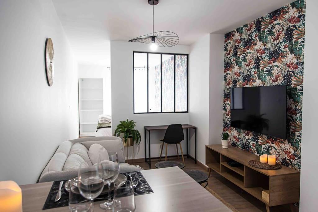 un salon avec un canapé et une télévision dans l'établissement L'Escapade-Hypercentre-parking privé-refait à neuf, à Châteauroux