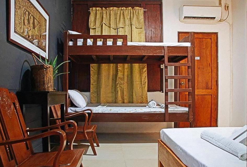a bedroom with a bunk bed with a desk and a chair at RedDoorz Hostel @ Deomar Hometel & Farm Cafe Ilocos Sur in Bantaoay