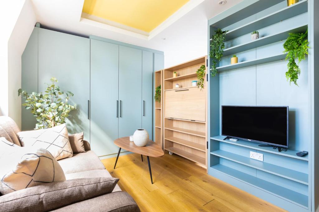 a living room with a couch and a tv at Cozy Apt in Central London in London